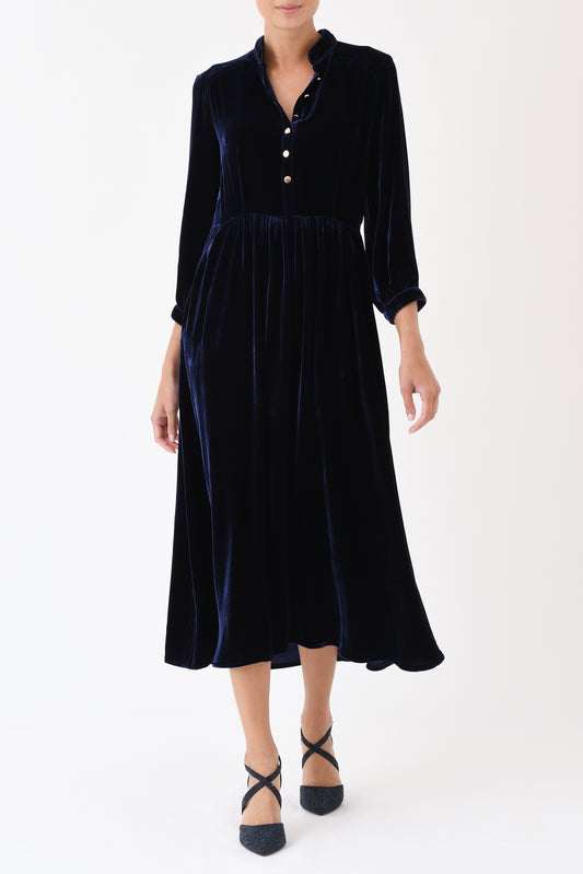 Woman wearing elegant navy velvet dress with button-front detail
