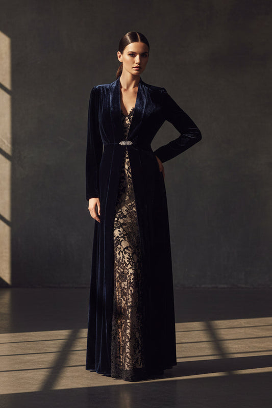 A long navy velvet coat with a deep V-neckline, long sleeves, and a thin silver rhinestone clasp at the waist, shown against a plain white background.
